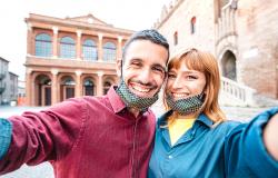 Smiling couple wearing face masks in Italy