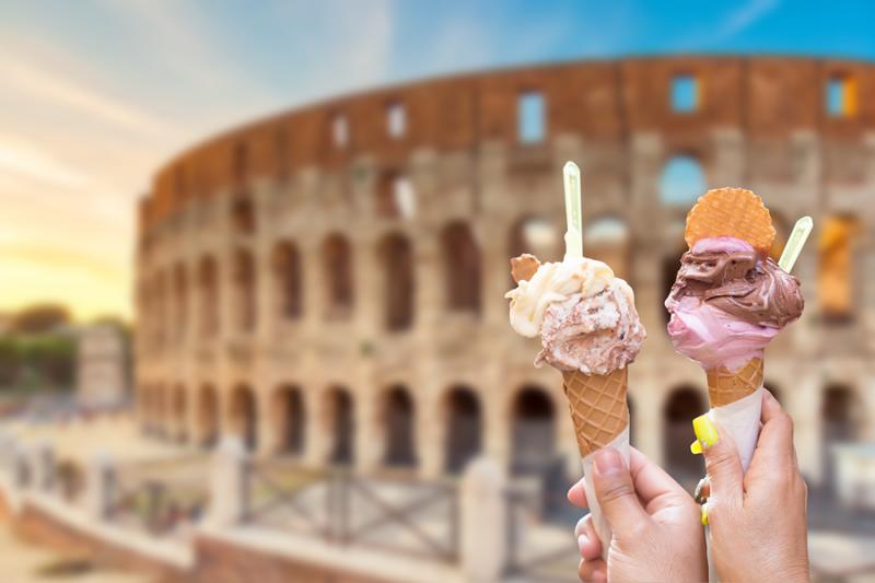 Hands holding gelato cones in front of Colosseum in Rome Italy