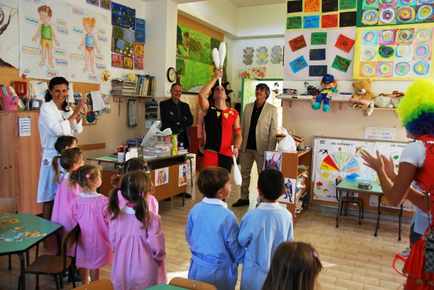 A juggler entertains children at school