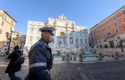 Policeman with face mask in front of Trevi fountain in Rome