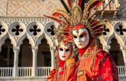 Two beautiful venetian carnival masks with the famous Doge Palace in the background 