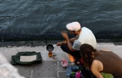 German tourists in Venice make coffee at Rialto Bridge by Grand Canal