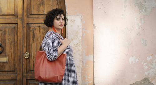 Saghar Setareh standing against a pink wall