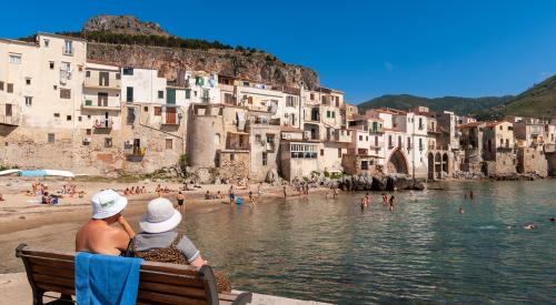 An elderly couple on the waterfront of Cefalu, Sicily / Photo: Alex Segre via Shutterstock