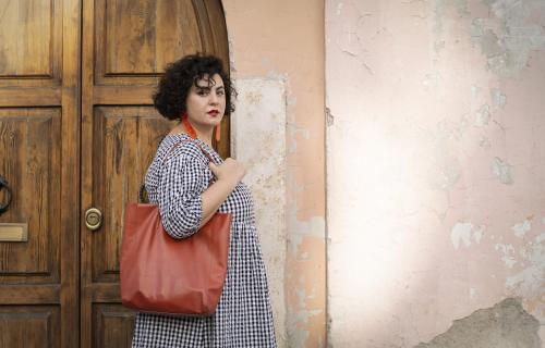 Saghar Setareh standing against a pink wall