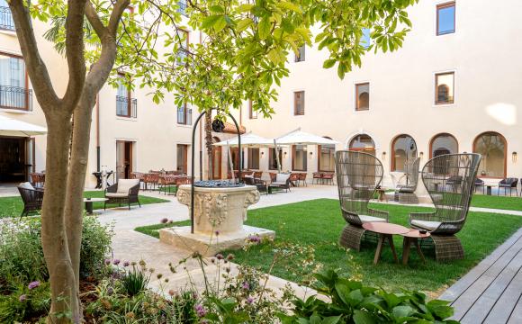 Courtyard at Ca’ di Dio, Venice, with lawn chairs and a tree