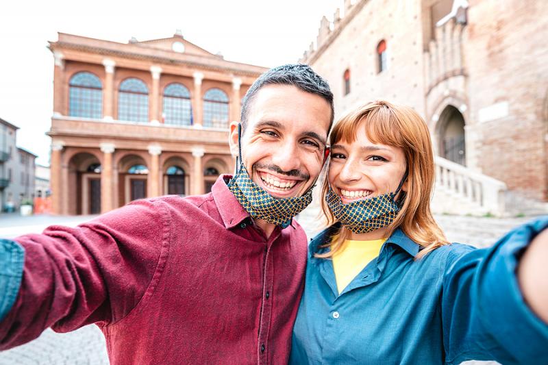 Smiling couple wearing face masks in Italy