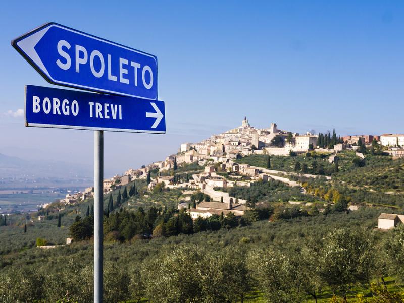 Road signs in Umbria with village in the background