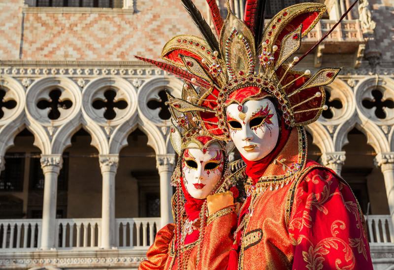 Two beautiful venetian carnival masks with the famous Doge Palace in the background 