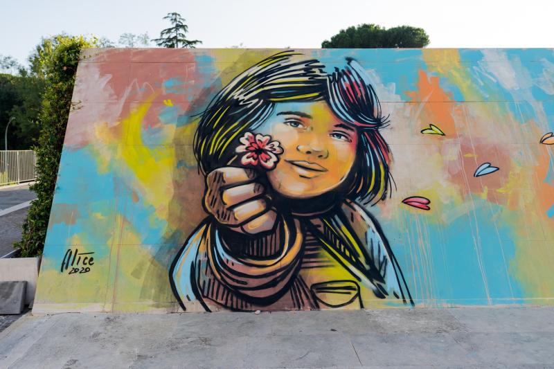 Wall painted by the artist with a little girl who give a flower