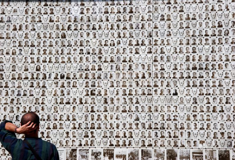 an observer admires photos of Italian partisans killed during the resistance, Bologna