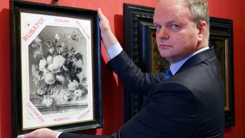 Uffizi director Eike Schmidt holds copy of painting stolen during World War II