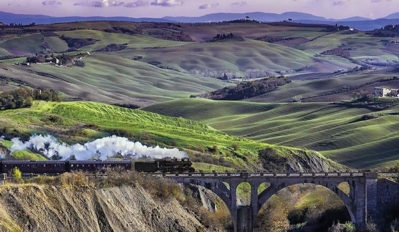 The Val D'Orcia steam train crossing the Tuscan hilly landscape