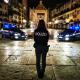 Police officer and cars patrolling an empty square in Verona at night